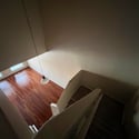 Looking down from the upper level, this photo captures the home's impressive vaulted ceilings, open staircase, and beautiful wood flooring that define the spacious living area.
