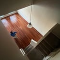 An elevated perspective highlights the dramatic two-story great room with beautiful wood flooring, soaring ceilings, and an open staircase that enhances the spacious feel of this Phoenix home.