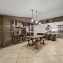 Gather in this elegant dining area featuring a custom built-in display cabinet with glass doors, wine storage, beverage refrigerator, and seamless access to the remodeled kitchen for effortless entertaining.