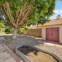 Featuring a detached storage shed, mature shade tree, decorative rock landscaping, and additional outdoor space, this backyard combines beauty and functionality for everyday living at this Glendale rental property.