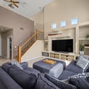 Designed for both entertaining and everyday comfort, the great room showcases dramatic ceilings, custom entertainment built-ins, oversized windows, and an open layout filled with natural light.