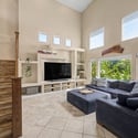 Bright windows, soaring ceilings, and custom built-in shelving create a welcoming living area that offers plenty of room for entertaining, relaxing, and enjoying views of the beautifully landscaped backyard.