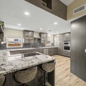 A large granite island anchors this beautifully updated kitchen, offering comfortable seating, premium finishes, abundant prep space, and an open layout ideal for entertaining family and guests.