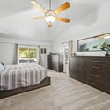 Escape to a spacious primary suite featuring vaulted ceilings, plush carpeting, oversized windows, and plenty of room for a sitting area, offering comfort and privacy at the end of each day.
