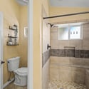 This custom walk-in shower features full-height tile surrounds, built-in bench seating, decorative accent tile, and a spacious design that combines comfort, style, and functionality.
