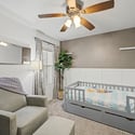 A welcoming secondary bedroom featuring plush carpeting, ceiling fan, stylish accent wall, and natural light. This flexible room works beautifully as a nursery, guest suite, or home office.