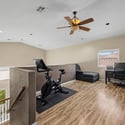The spacious upstairs loft is ideal for a home office, exercise room, game room, or additional family space, featuring wood-look flooring, recessed lighting, and an open layout.