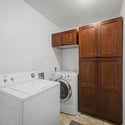 The dedicated laundry area features built-in cabinetry, washer and dryer hookups, and extra storage to help keep daily routines organized and efficient.
