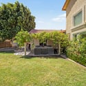 This private backyard showcases mature landscaping, lush grass, established shade trees, and a covered patio, offering a comfortable outdoor setting with plenty of room to enjoy Arizona living in Glendale.