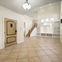 A welcoming front entry showcases soaring ceilings, elegant architecture, tile flooring, and a custom entertainment feature that creates a memorable first impression in this Glendale home.