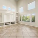Bright windows, expansive ceilings, and custom built-in shelving combine to create a welcoming living space ideal for entertaining, relaxing, or spending time with family.