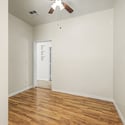 This spacious bedroom combines updated flooring, vaulted ceilings, and a ceiling fan to create a welcoming retreat with flexible use for guests, family members, or a home office in this Glendale home.