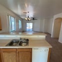 Spacious kitchen with breakfast bar seating, dual-basin sink, and an open layout connecting seamlessly to the living room. Ideal for entertaining and everyday convenience.