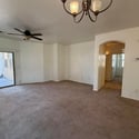 Spacious living area with ceiling fan, plush carpeting, and sliding door access to the backyard patio. The open layout provides excellent flexibility for everyday living and entertaining.