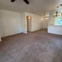 Open living room with breakfast bar, arched architectural details, and plenty of room for multiple furniture arrangements. Designed for comfortable everyday living.