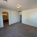 Spacious primary suite with plush carpeting, natural light, and private access to the ensuite bath and walk-in closet. A comfortable retreat after a long day.