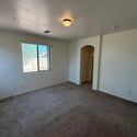 Well-sized bedroom featuring abundant natural light, plush carpeting, and a functional layout that easily accommodates a variety of furniture styles.