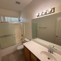 Spacious full bathroom featuring dual sinks, a tub and shower combination, generous countertop space, and a bright, functional layout ideal for daily routines.