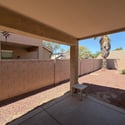 Enjoy outdoor living under the covered patio overlooking a private backyard with easy-care desert landscaping, perfect for entertaining or unwinding.