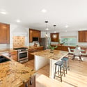 Discover a spacious kitchen with granite island, an abundance of cabinets, and natural light.
