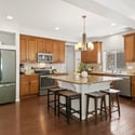A warm and welcoming kitchen with granite countertops, storage, and an oversized island presents a space that is perfect for slow weekend mornings and chats after dinner.