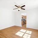 Bright and open living space featuring a ceiling fan and easy access to a modern kitchen.
