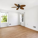 Bright, spacious room featuring large windows and a ceiling fan, perfect for personalizing to your taste.