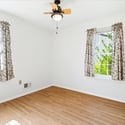 Bright and inviting bedroom with abundant natural light and a ceiling fan for comfort.
