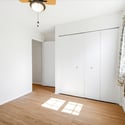 Light-filled room featuring ample closet space and a ceiling fan, ideal for cozy living or working.
