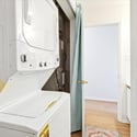 Convenient laundry area with stacked washer and dryer, adjacent to accessible living spaces for efficiency.