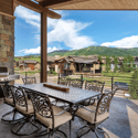Spacious outdoor dining area with gourmet gas grill and ski mountain views.