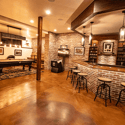 Spacious entertainment area featuring a custom bar, billiards, and unique textured finishes throughout.