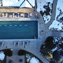 Expansive outdoor pool area featuring spacious lounging options, surrounded by picturesque landscaping and winter ambiance.