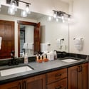 Bunk room en suite bathroom featuring sleek countertops, contemporary lighting, and ample storage for everyday essentials.