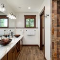 Spacious bathroom featuring dual sinks, a unique stone shower, and ample natural light.