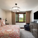 Lower-level spacious king bedroom with twin trundle beds, featuring modern amenities, and an en suite double sink bath with shower.