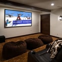 Enjoy cinematic experiences in this spacious home theater featuring oversized seating and modern audio-visual equipment.