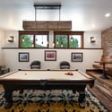 Spacious game room features a billiard table, TVs, game console, and a custom bar with multiple tables and seating options.
