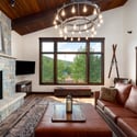 Spacious "Great Room" with mountain views, a stone fireplace, and modern fixtures, perfect for gatherings. The open floor plan connects the great room to the kitchen and dining areas. Sliding glass doors open to a back deck featuring Emerald Mountain views.