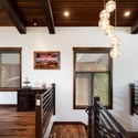 The upper level features wood accents, modern light fixtures, and large windows that invite natural light.