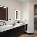 Modern bathroom featuring dual sinks, sleek fixtures, and a spacious walk-in shower for optimal convenience.