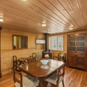 Cozy wooden interior featuring a dining area, and a wood stove for an inviting atmosphere.
