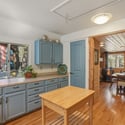 Bright kitchen featuring blue cabinetry, natural wood elements, and inviting views of the outdoor surroundings.