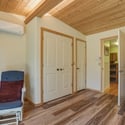 Bright and airy room featuring wooden accents, dual closets, and convenient access to adjoining spaces.