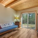 Bright living space with wooden beams and direct access to a private outdoor view.