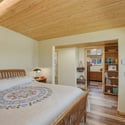 Bright and inviting bedroom featuring wood accents, abundant natural light, and convenient access to adjoining spaces.