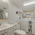This functional laundry room features convenient appliances and ample natural light from a large window.