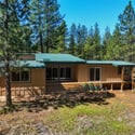 This cozy home nestled among tall pines offers a perfect blend of comfort and nature.