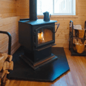 Cozy wood-burning stove enhances warmth and comfort in this inviting cabin space, perfect for gatherings.