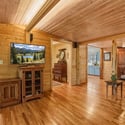 Cozy living area features natural wood finishes and ample sunlight, creating a warm, inviting atmosphere.
